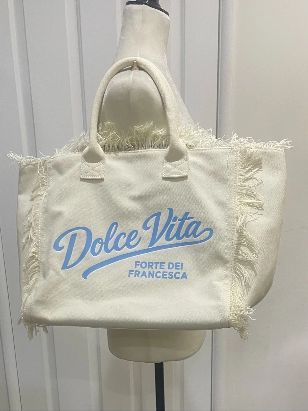 Dolce Vita Cream Canvas Fringe Tote with Light Blue Logo